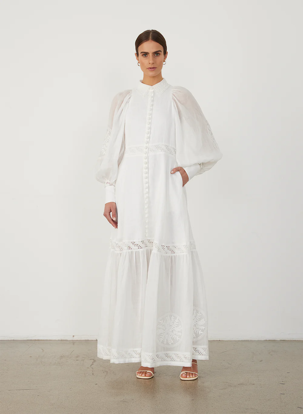 Indulge in timeless elegance with Theodora Maxi Dress by Joslin. Crafted from European Flax Linen, this dress features a classic collar and a shirt fit at the bodice, falling into a full skirt. The stunning ramie organdy sleeves and hem panel add an ethereal touch. Adorned with intricate cotton doilys and crochet buttons for a sophisticated finish.