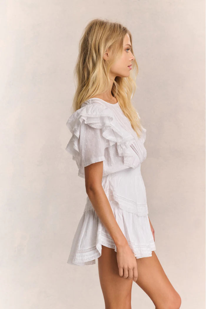 Elevate your style with the Natasha Heritage Mini Dress! The double ruffled flutter sleeves effortlessly accentuate the elasticated waist, while delicate lace trims add a touch of femininity. Perfect for any occasion, this dress exudes elegance and ease.