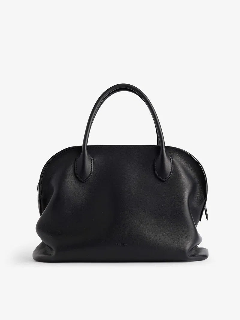 The Agnes tote by The Row combines understated luxury with everyday practicality. Crafted from polished saddle leather, this sophisticated bag features a softly slouched silhouette that moves with you, paired with sturdy tubular handles for effortless carrying. The secure zipper closure keeps your essentials protected while maintaining the bag's refined aesthetic. Perfect for those who appreciate timeless design and quality craftsmanship, the Agnes transitions seamlessly from work to weekend.