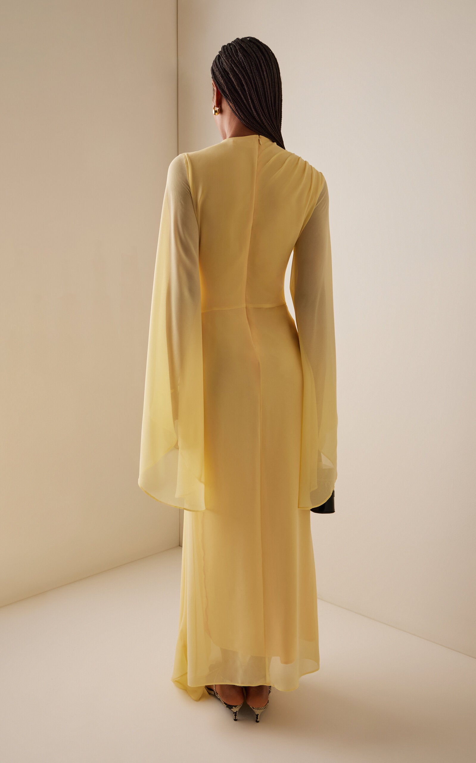 The Hausos Chiffon Maxi Dress by De La Vali features a graceful ankle-to-floor length with a dipped waist seam that enhances your natural silhouette. Its draped skirt with godet adds movement and flow, while the asymmetric neckline offers a unique touch. Long pagoda sleeves create a dramatic flare, combining elegance with a bold statement. Designed to make you feel confident and effortlessly empowered in every occasion.