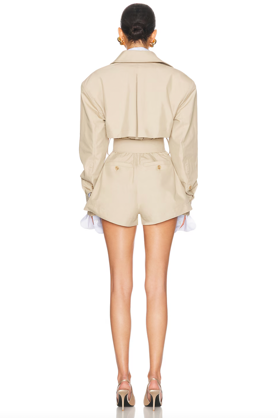 This Short Trench Jumpsuit combines sharp tailoring with practical design. Featuring a double-breasted front and structured shoulders, it creates a polished silhouette. Made from durable twill, it offers four pockets and buttoned cuffs for subtle sophistication. The optional belt lets you personalize your fit, making it a stylish, versatile choice for any occasion.