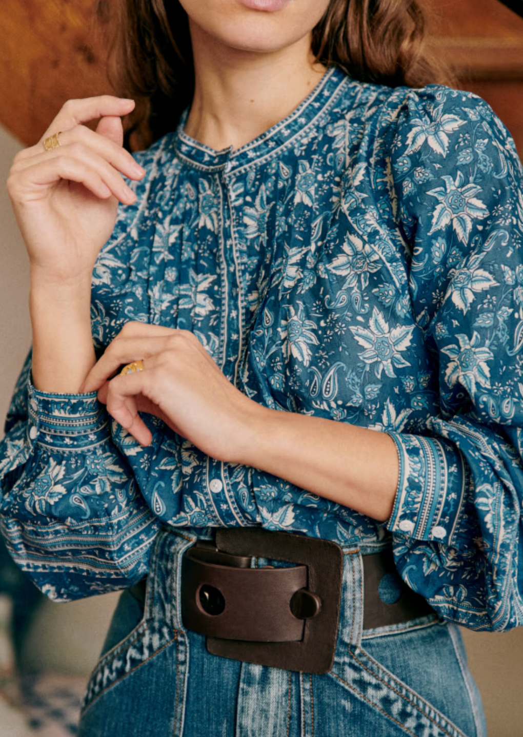 The Mariana Shirt by Sezane combines classic sophistication with modern style. Featuring an officer collar and button-down front, this long sleeve shirt offers a polished look perfect for any occasion. Its wide sleeves are elegantly gathered at the shoulders and cuffs, creating a graceful silhouette that cinches at the wrist for a tailored finish. Elevate your wardrobe with this statement piece that balances comfort and chic design effortlessly.