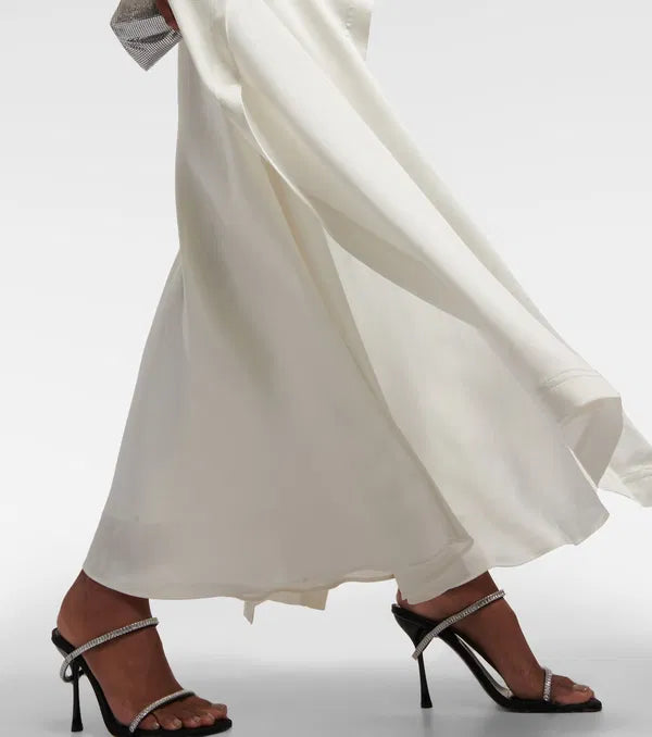 Sparkle and shine in the Amory Caped Gown by Simkhai. This bridal gown features intricate lace work, architectural silhouette, and luxurious materials for effortless chic and sophistication on your special day. Designed to flatter and accentuate the female form, it's the perfect choice for any bride looking for quality and craftsmanship.