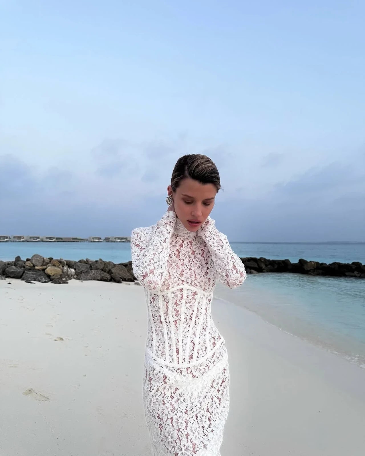 The Isadora gown by The New Arrivals Ilkyaz Ozel epitomizes refined elegance with its pristine white silhouette and architectural design. Featuring a structured boned bodice that sculpts the figure with precision, this statement piece showcases a sophisticated mock neck and innovative cuff zips for versatile styling. The concealed rear zip fastening ensures a seamless, polished finish. Perfect for those who appreciate couture-inspired details and timeless sophistication.