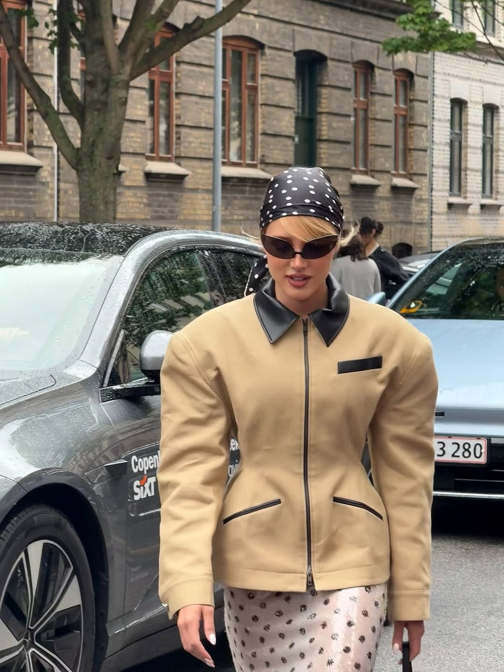 Hourglass Canvas Jacket Master the art of effortless sophistication with this canvas work jacket that refuses to compromise on style. The sculpted hourglass silhouette flatters your frame while bold padded shoulders project quiet confidence. A striking leather collar elevates the everyday, transforming a utilitarian piece into a statement. Adjustable buttoned tabs at the back give you complete control over your fit—customize it to perfection.