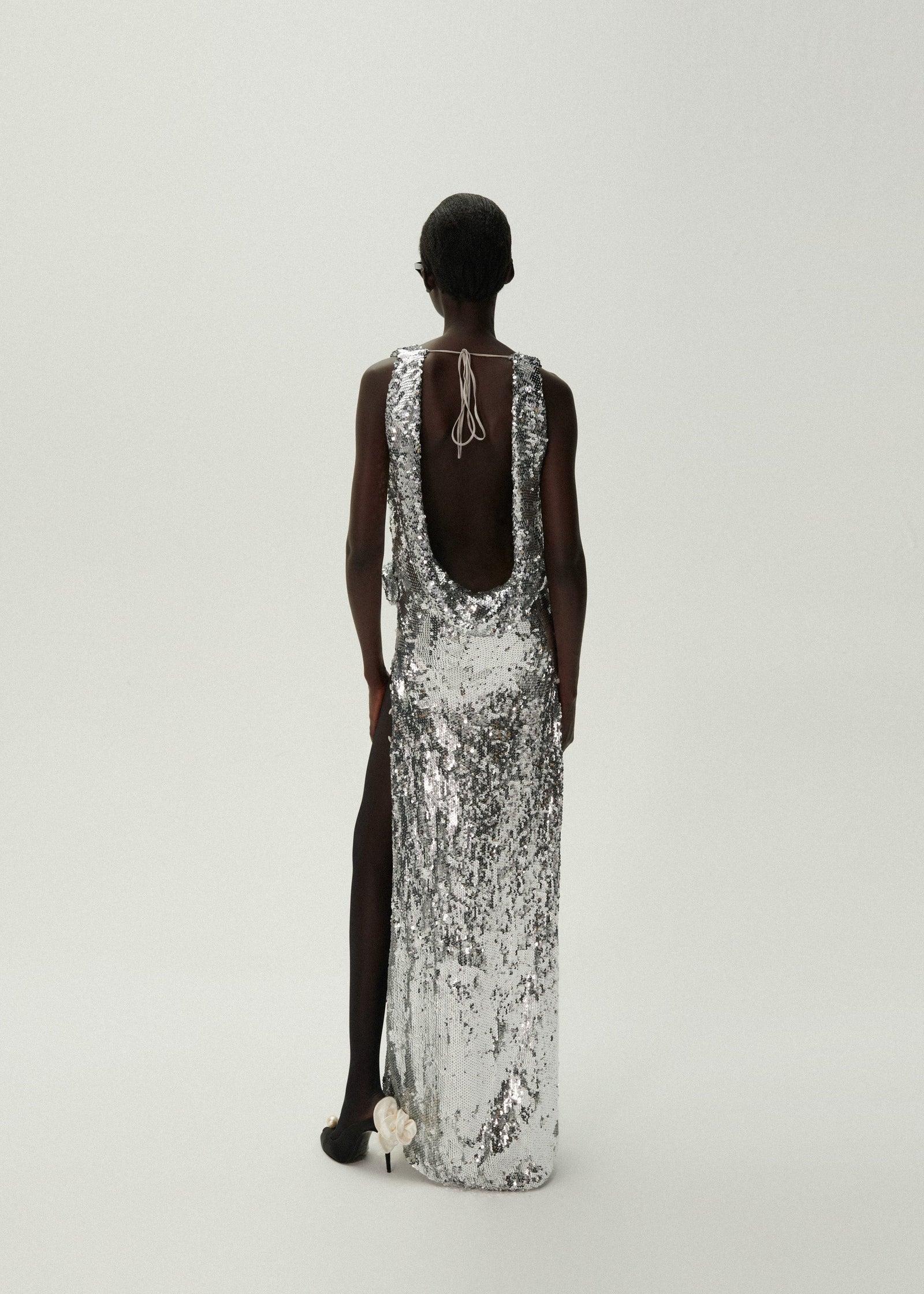 Indulge in luxury with the handnetted sequins and 3D rose appliqué of the Magda Butrym cowl neck dress. Crafted with a plunging neckline and draped back, this silver creation exudes elegance and sophistication. Take center stage and make a statement with this exclusive piece.