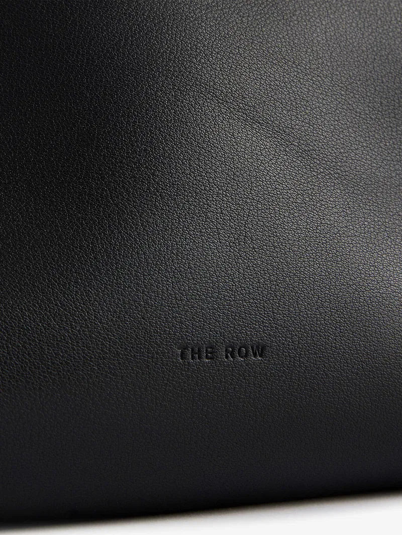 The Agnes tote by The Row combines understated luxury with everyday practicality. Crafted from polished saddle leather, this sophisticated bag features a softly slouched silhouette that moves with you, paired with sturdy tubular handles for effortless carrying. The secure zipper closure keeps your essentials protected while maintaining the bag's refined aesthetic. Perfect for those who appreciate timeless design and quality craftsmanship, the Agnes transitions seamlessly from work to weekend.