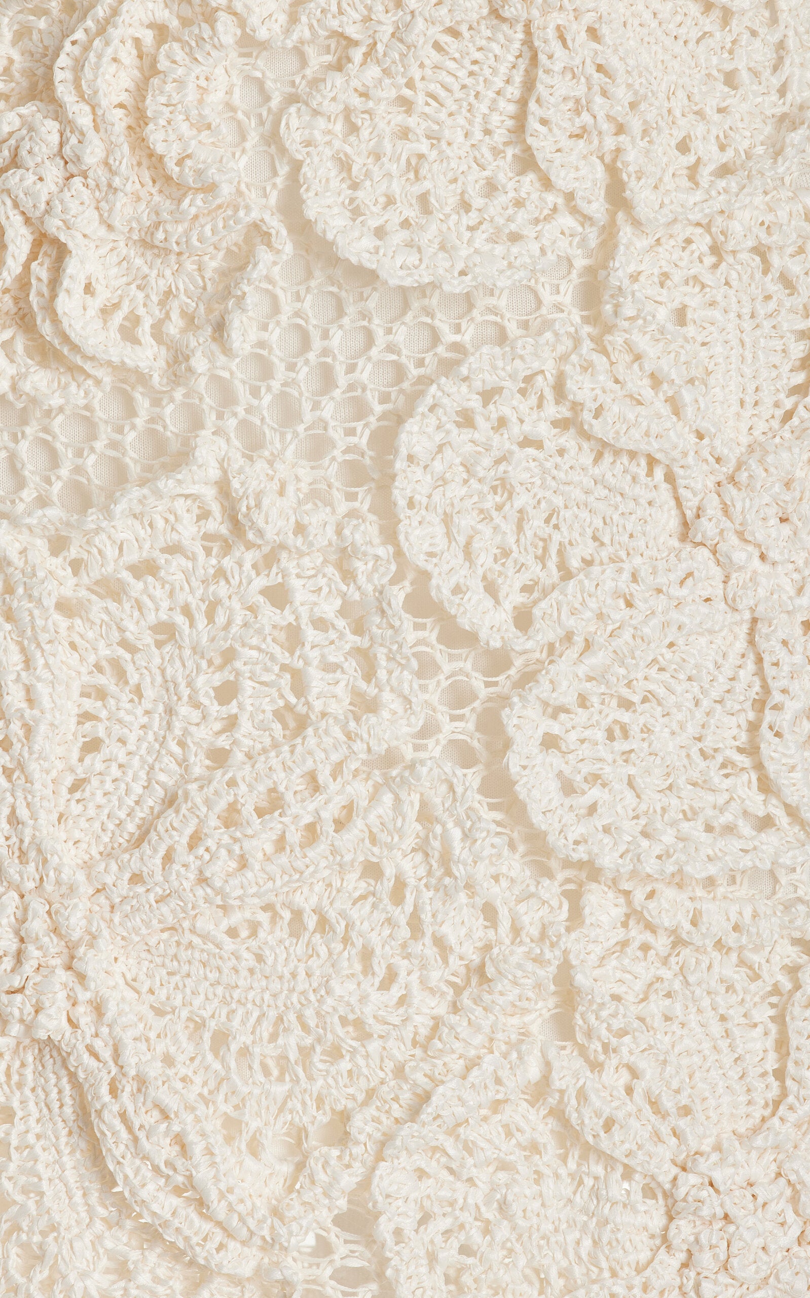 The Kendria mini dress is an effortlessly chic statement piece that commands attention. This slim-fitting design features a striking one-shoulder neckline that flatters and elongates, while intricate crochet work showcases delicate eyelet patterns. Three-dimensional floral details add romantic texture and dimension, creating a dress that's both sophisticated and playfully feminine. 