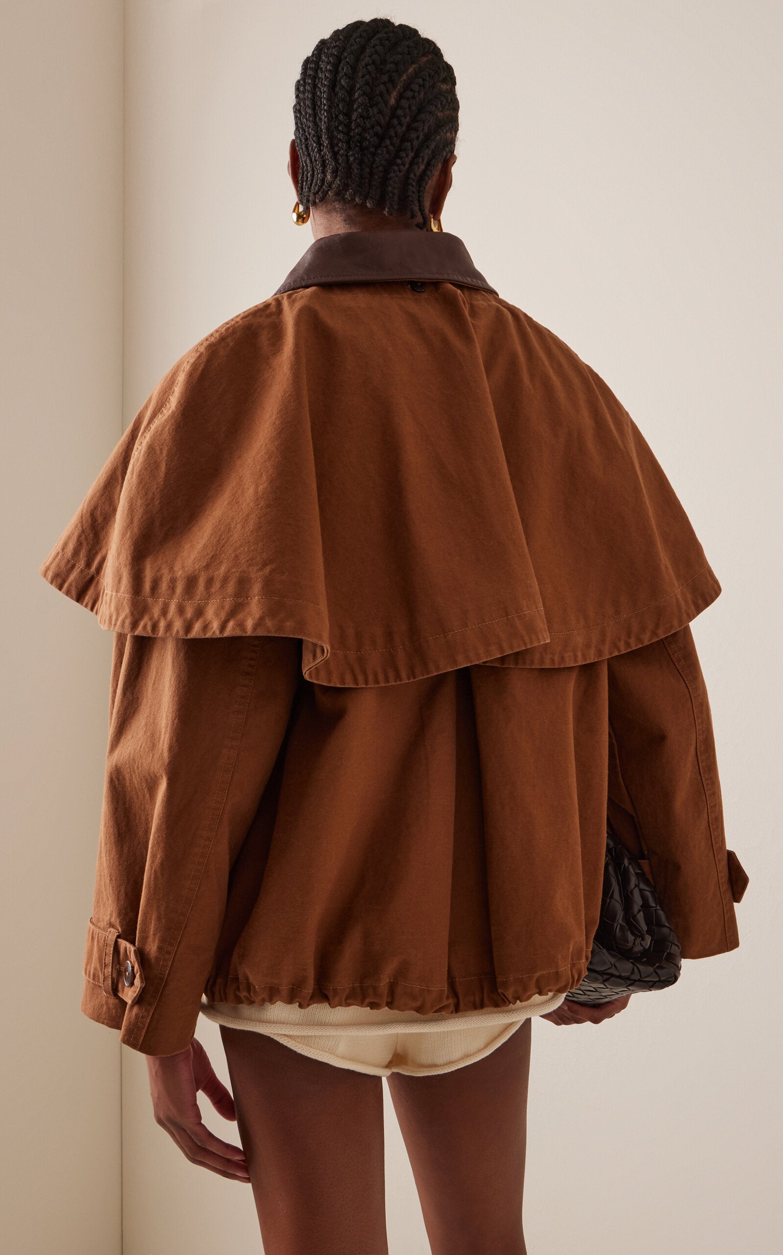 Embrace effortless sophistication with the Carolyn Cape-Detailed Cotton Workwear Jacket by SEA NY. This statement piece combines utilitarian charm with unexpected elegance, featuring a structured oversized silhouette crafted from crisp cotton canvas. The signature flouncy capelet adds a playful twist to classic workwear styling, making it perfect for elevating everyday looks or creating bold, fashion-forward outfits. 