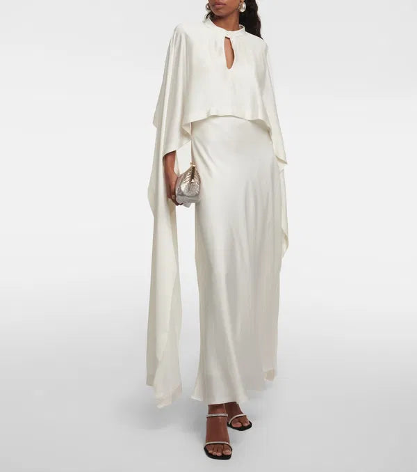 Sparkle and shine in the Amory Caped Gown by Simkhai. This bridal gown features intricate lace work, architectural silhouette, and luxurious materials for effortless chic and sophistication on your special day. Designed to flatter and accentuate the female form, it's the perfect choice for any bride looking for quality and craftsmanship.