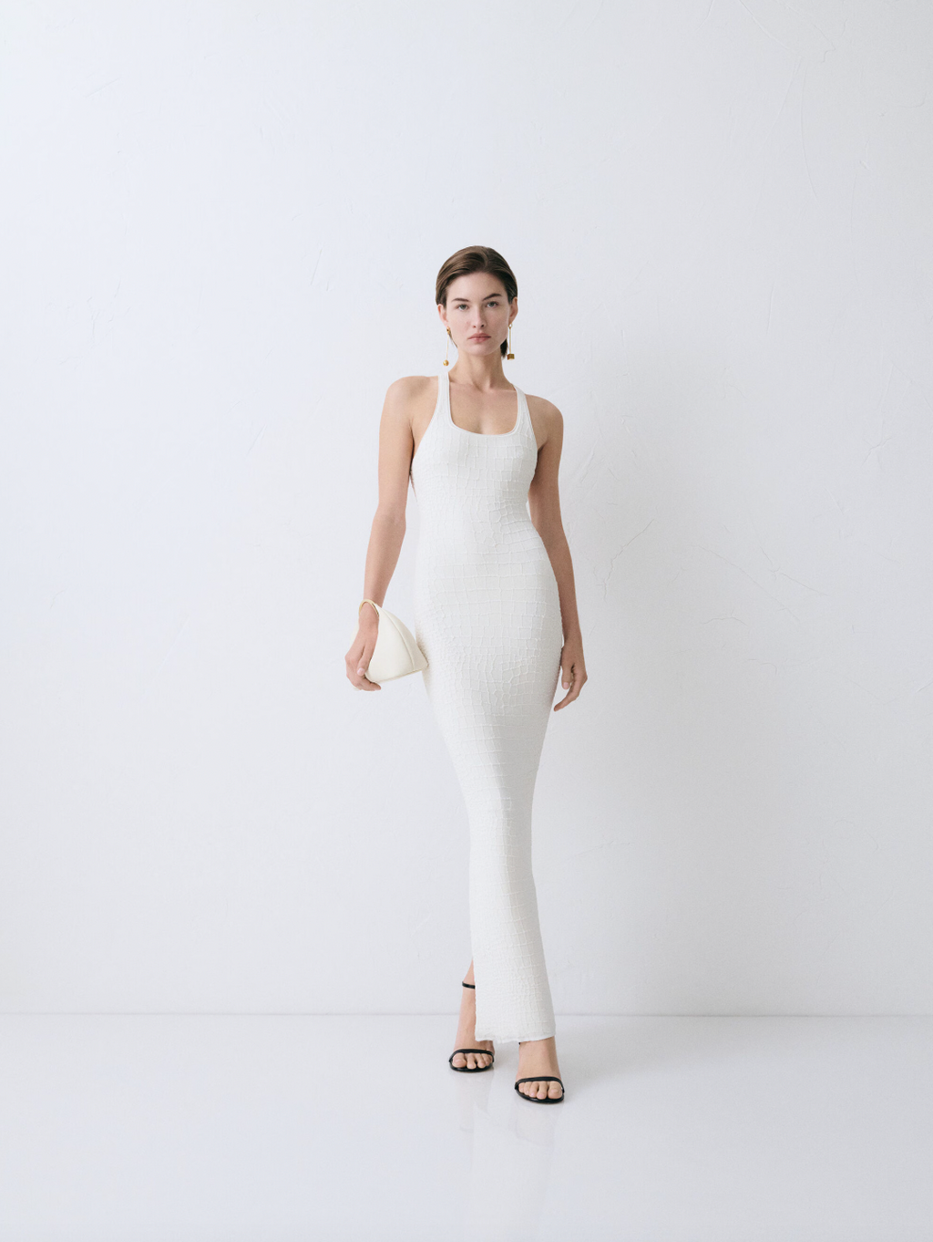 The Scala dress by Jacquemus combines elegance and edge with its long, fitted silhouette crafted from crocodile-embossed stretch viscose. Its square neckline and sleeveless racerback design enhance your natural shape while offering comfort and style. A long back slit adds a daring touch, and the subtle “J” locker loop detail sets this dress apart. Perfect for making a bold statement at any event.