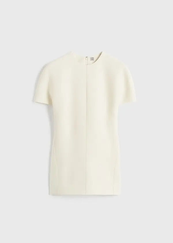 Discover understated luxury with this cap-sleeve top by Toteme, where contemporary design meets timeless sophistication. The elongated cut creates a flattering silhouette while twisted seams introduce subtle architectural detail. Constructed from premium double-faced cady blended with wool and silk, it delivers exceptional comfort without compromising on durability. A hidden back zipper provides a clean, refined finish—perfect for seamless layering or standalone elegance. 