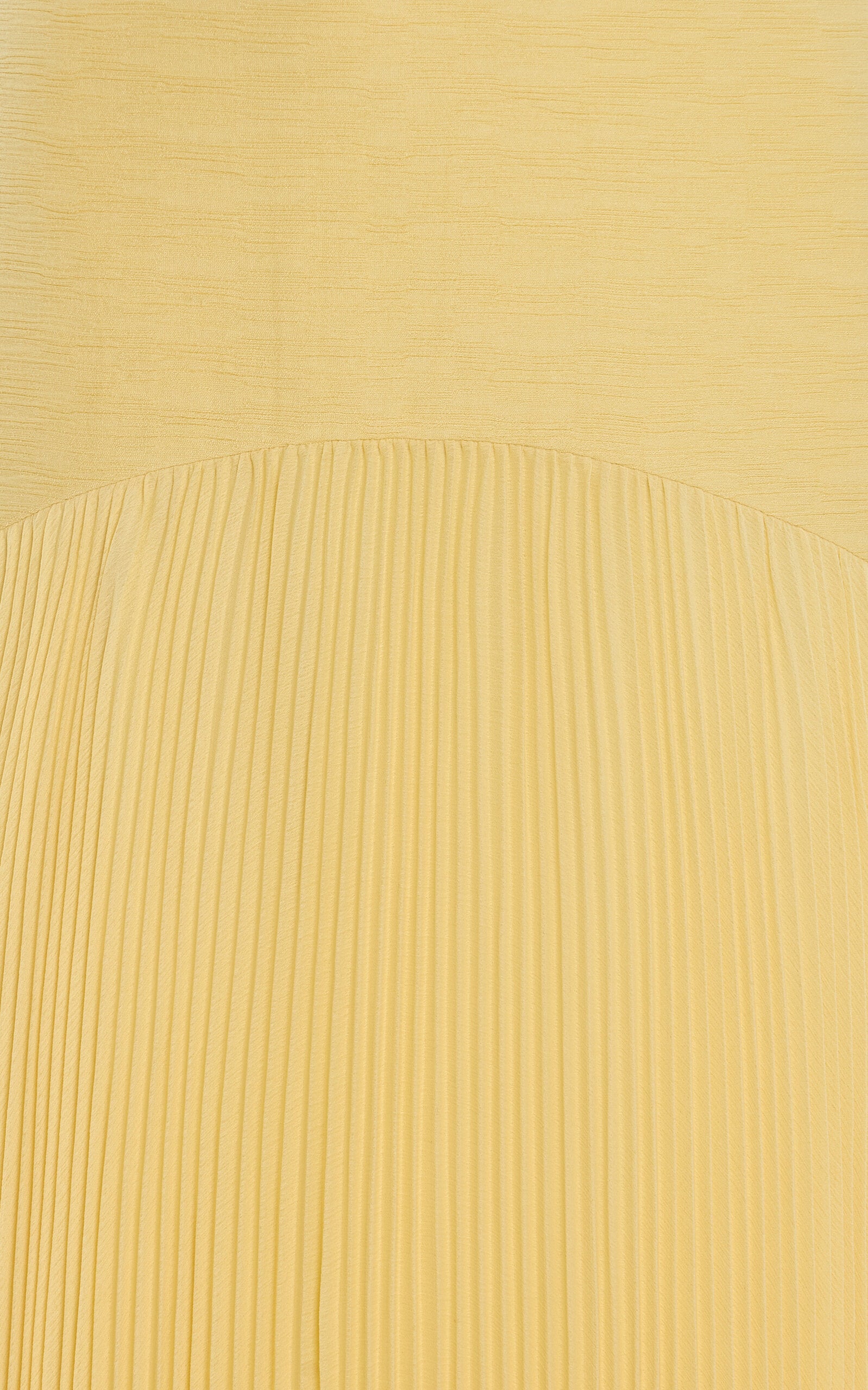 The Sunniva Dress showcases a fitted strapless bodice with a graceful curved dropped waist, seamlessly flowing into a delicate plisse skirt. Its elegant silhouette highlights your figure while offering effortless movement. Pair it with bold statement earrings to complete a look that embodies refined sophistication and modern style. Perfect for making a lasting impression at any event.