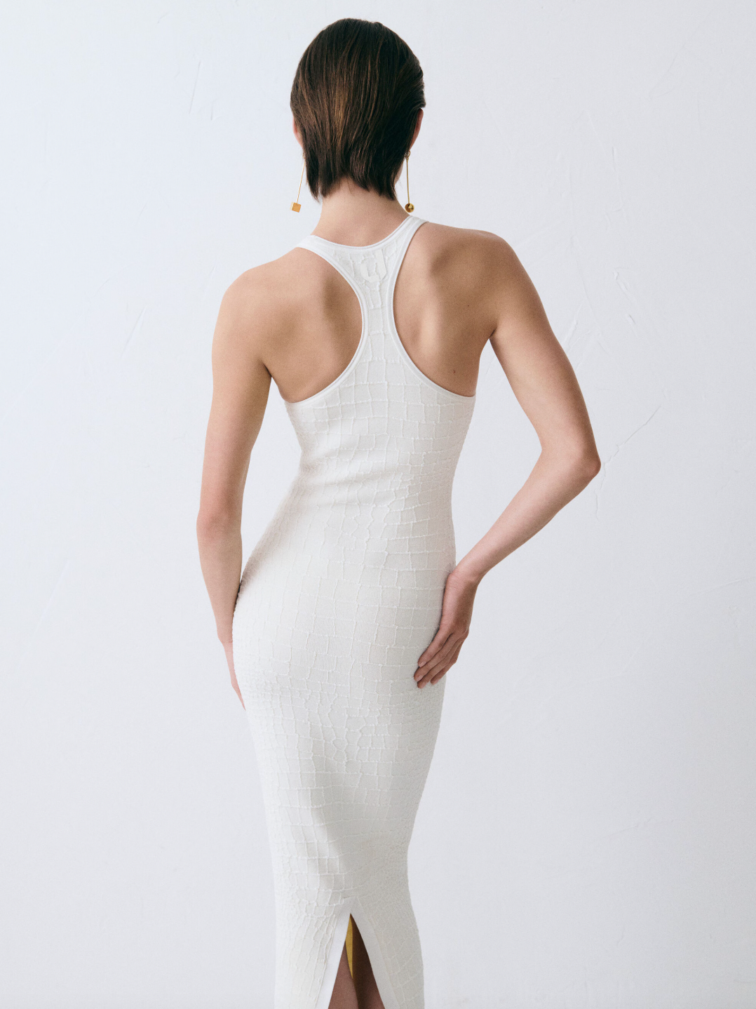 The Scala dress by Jacquemus combines elegance and edge with its long, fitted silhouette crafted from crocodile-embossed stretch viscose. Its square neckline and sleeveless racerback design enhance your natural shape while offering comfort and style. A long back slit adds a daring touch, and the subtle “J” locker loop detail sets this dress apart. Perfect for making a bold statement at any event.