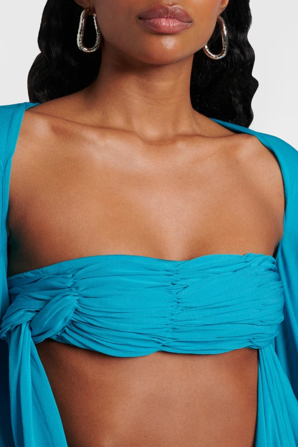 Elevate your wardrobe with the Gyre Cape Effect Dress by Christopher Esber. Crafted from soft jersey, this vibrant turquoise maxi features a dramatic cape-effect overlay and a sleek bandeau bodice that flows to the floor, enhancing your silhouette with delicate draping. Designed for those who seek effortless elegance, this dress makes a bold statement at any special event, especially when complemented with silver jewelry for a touch of refined sophistication.