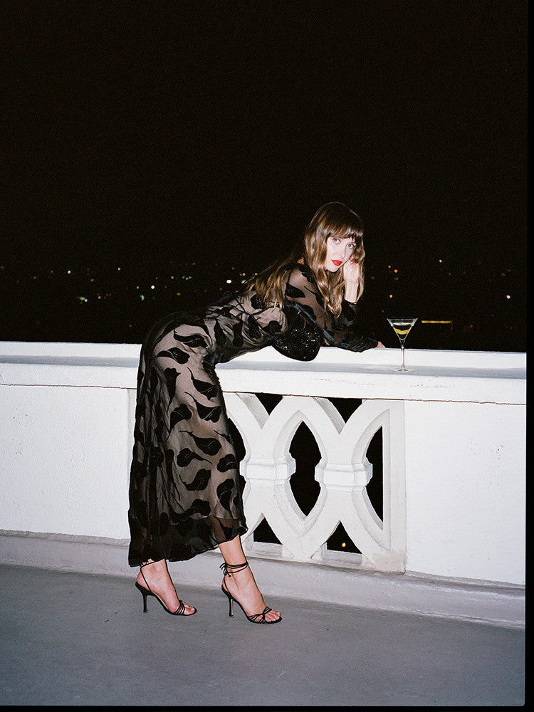 The Inka Dress in Falling Lily Devore combines elegance and subtle allure with its long, semi-sheer design that offers just the right amount of coverage. Featuring a deep neckline and a bias-cut skirt, it captures the ethereal grace of Kate Bush and the bohemian spirit of Joni Mitchell. Ideal for cooler summer nights, this dress pairs beautifully with sky-high heels to create a look of effortless, sexy femininity.