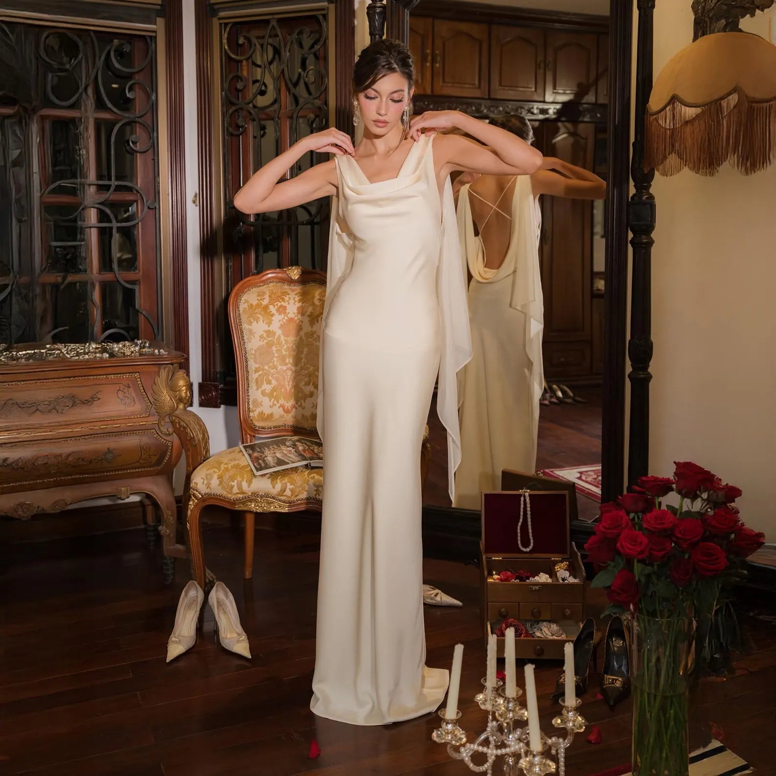 The Amora Gown is a stunning silk charmeuse dress that exudes grace and sophistication. Its white fabric catches the light with a radiant glow, while the open back with delicate cross straps and soft cowl drape create a captivating silhouette. Flowing silk panels add movement and elegance, making it perfect for evening events, red carpet affairs, or a unique wedding dress. Designed to flatter every figure, Amora blends vintage glamour with modern sensuality for a look that is both timeless and unforgettable