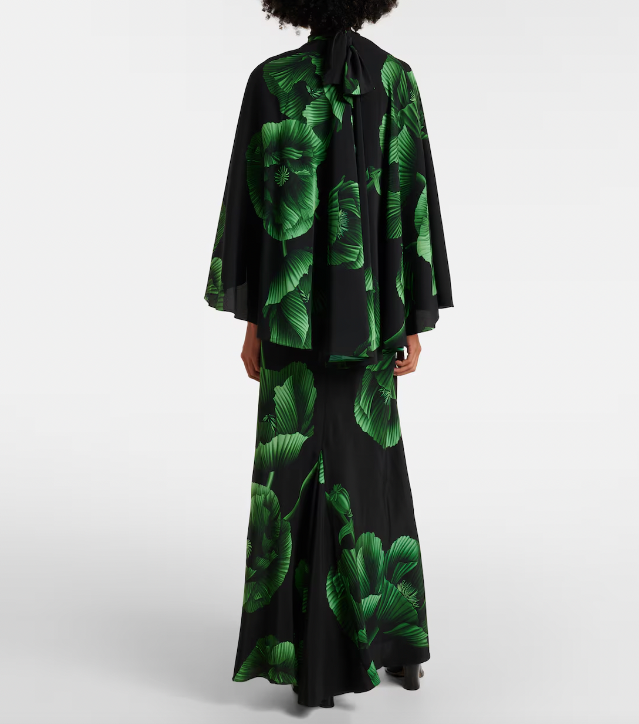 Experience elegance with the Floral Embroidered Silk Gown in green by Johanna Ortiz. Crafted from fluid silk, this floor-grazing gown showcases delicate floral embroidery and is enhanced by a dramatic draped cape detail. Perfect for making a graceful statement, it combines luxurious comfort with timeless sophistication.
