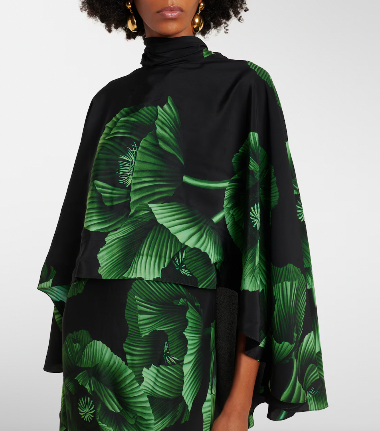 Experience elegance with the Floral Embroidered Silk Gown in green by Johanna Ortiz. Crafted from fluid silk, this floor-grazing gown showcases delicate floral embroidery and is enhanced by a dramatic draped cape detail. Perfect for making a graceful statement, it combines luxurious comfort with timeless sophistication.