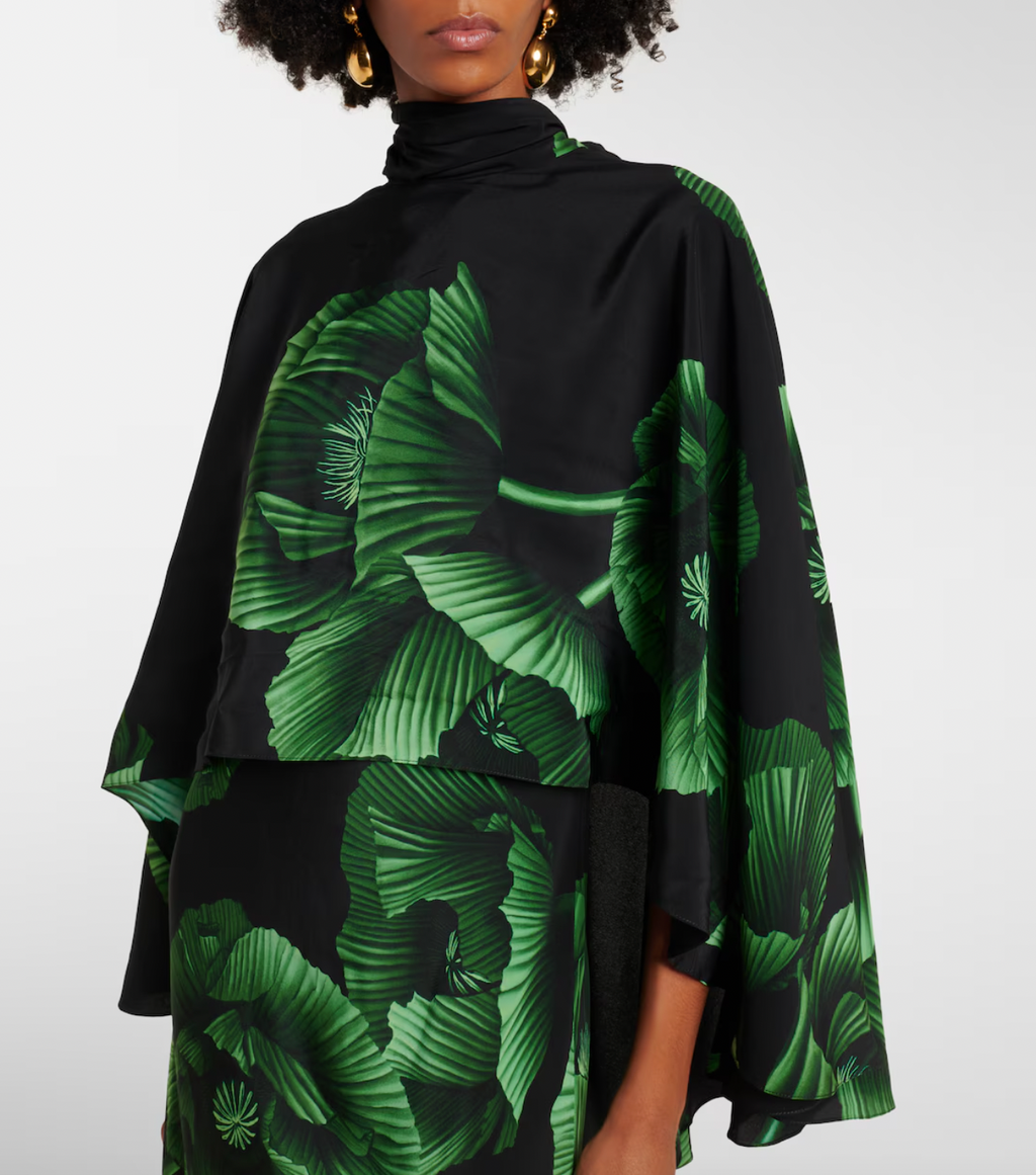 Experience elegance with the Floral Embroidered Silk Gown in green by Johanna Ortiz. Crafted from fluid silk, this floor-grazing gown showcases delicate floral embroidery and is enhanced by a dramatic draped cape detail. Perfect for making a graceful statement, it combines luxurious comfort with timeless sophistication.