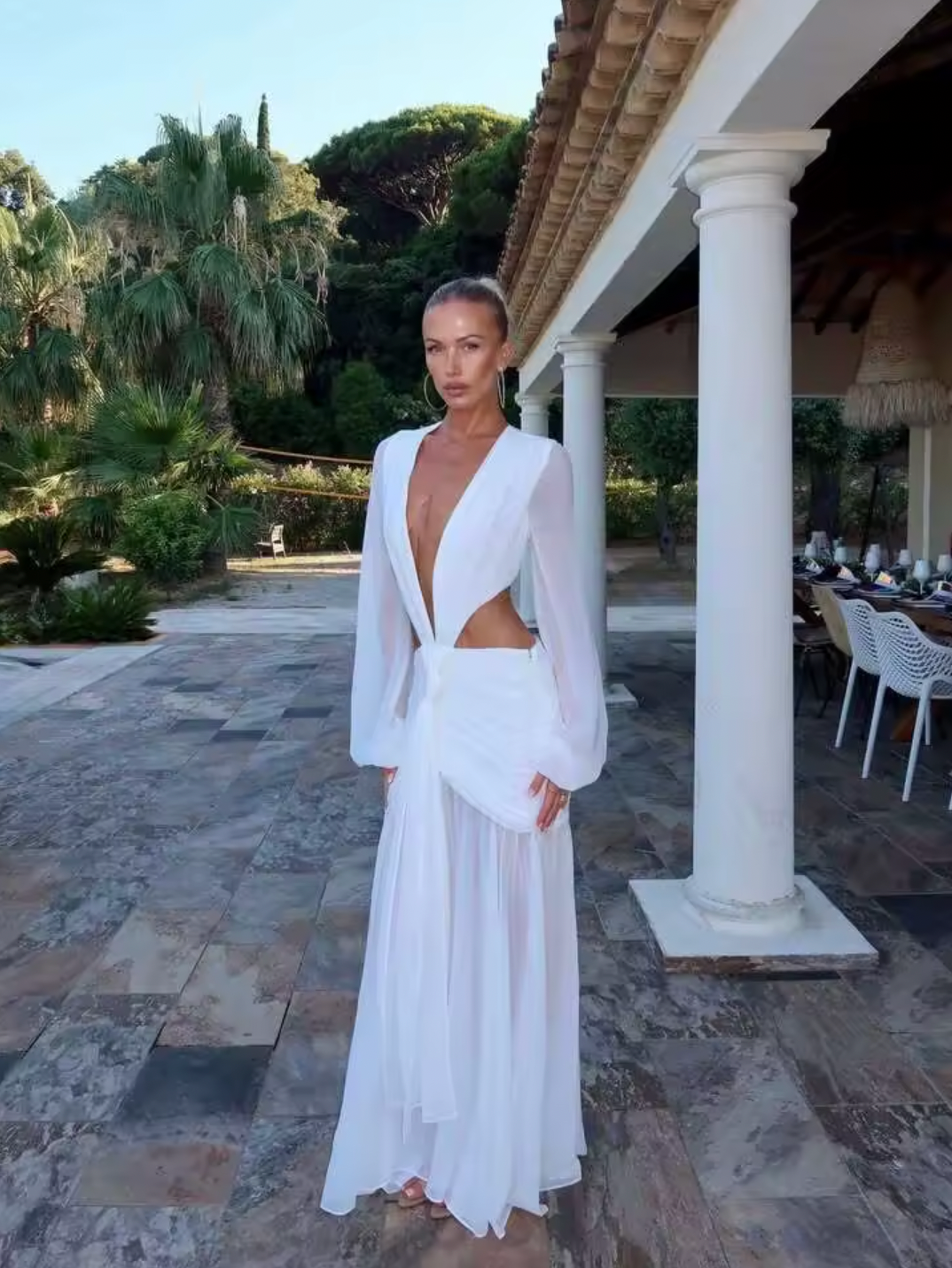 The Andrina Maxi Dress is a stunning statement piece that combines romance with modern elegance. Crafted from delicate chiffon, this maxi features long, sheer blouson sleeves and a daring deep plunge neckline that exudes confidence. The open lace-up back with adjustable ties allows you to customize your fit while showcasing an alluring silhouette. 