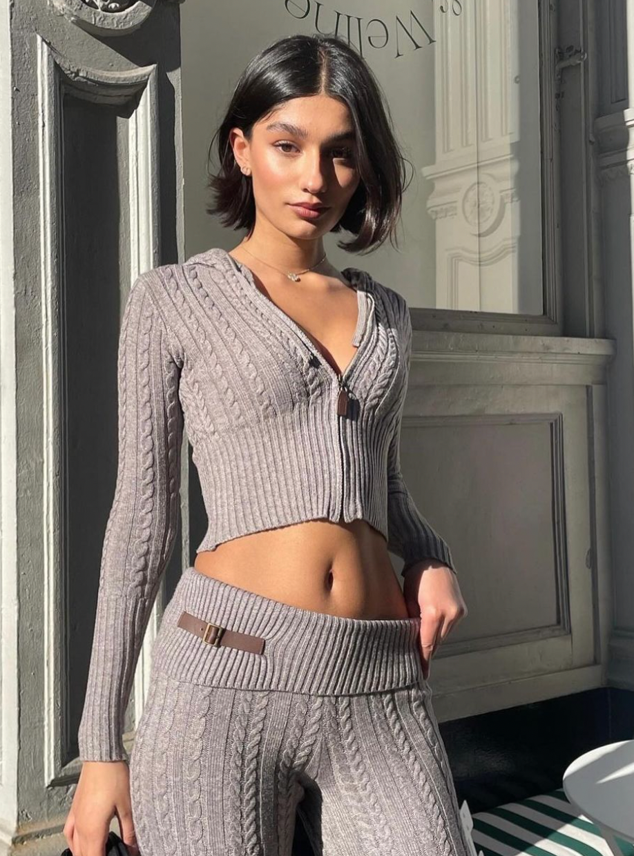 Introducing the Fleur Pant in Dark Pearl by Frankies Bikinis - your new favorite addition to your wardrobe! With its low rise fit, ribbed rollover waist, and cozy cable cloud knit fabric, you'll feel both stylish and comfortable. Complete with vintage-inspired hardware + trim and flared legs, Fleur is designed to flatter every size and stand the test of time.