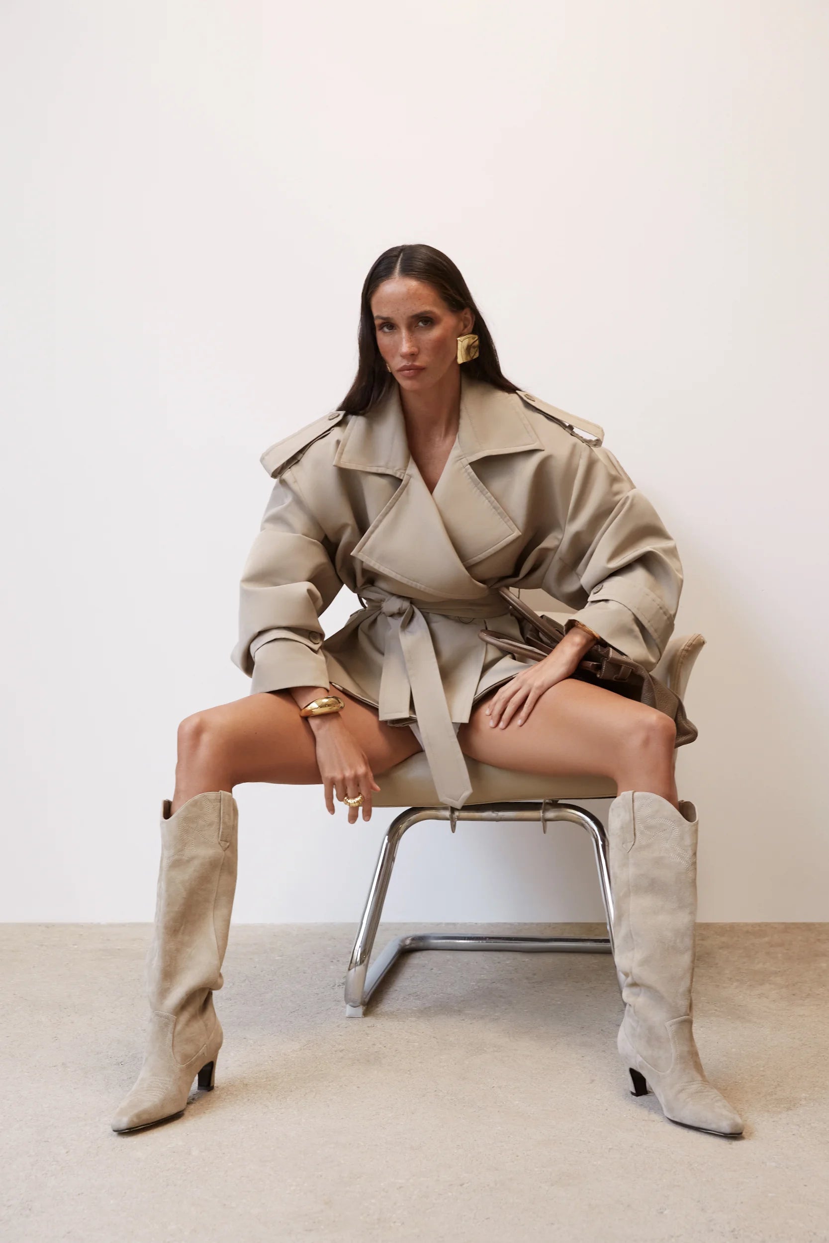 Elevate your wardrobe with this cropped beige trench coat, designed to blend timeless elegance with modern style. Its tailored fit effortlessly complements any outfit, while the neutral beige tone adds versatile sophistication. Ideal for layering, this coat offers both comfort and a chic silhouette, making it a must-have piece for your collection.