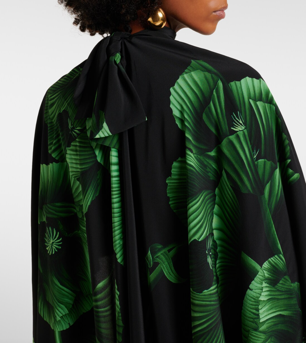 Experience elegance with the Floral Embroidered Silk Gown in green by Johanna Ortiz. Crafted from fluid silk, this floor-grazing gown showcases delicate floral embroidery and is enhanced by a dramatic draped cape detail. Perfect for making a graceful statement, it combines luxurious comfort with timeless sophistication.