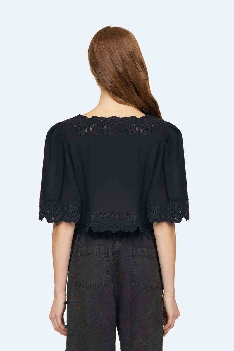 Elevate your wardrobe with the effortlessly elegant Baylin Top in Black by SEA. Delicate lace detailing and front tie closures exude sophistication and charm, while the flowy short sleeves add a touch of femininity. Luxurious and versatile, this top is a must-have for any occasion.