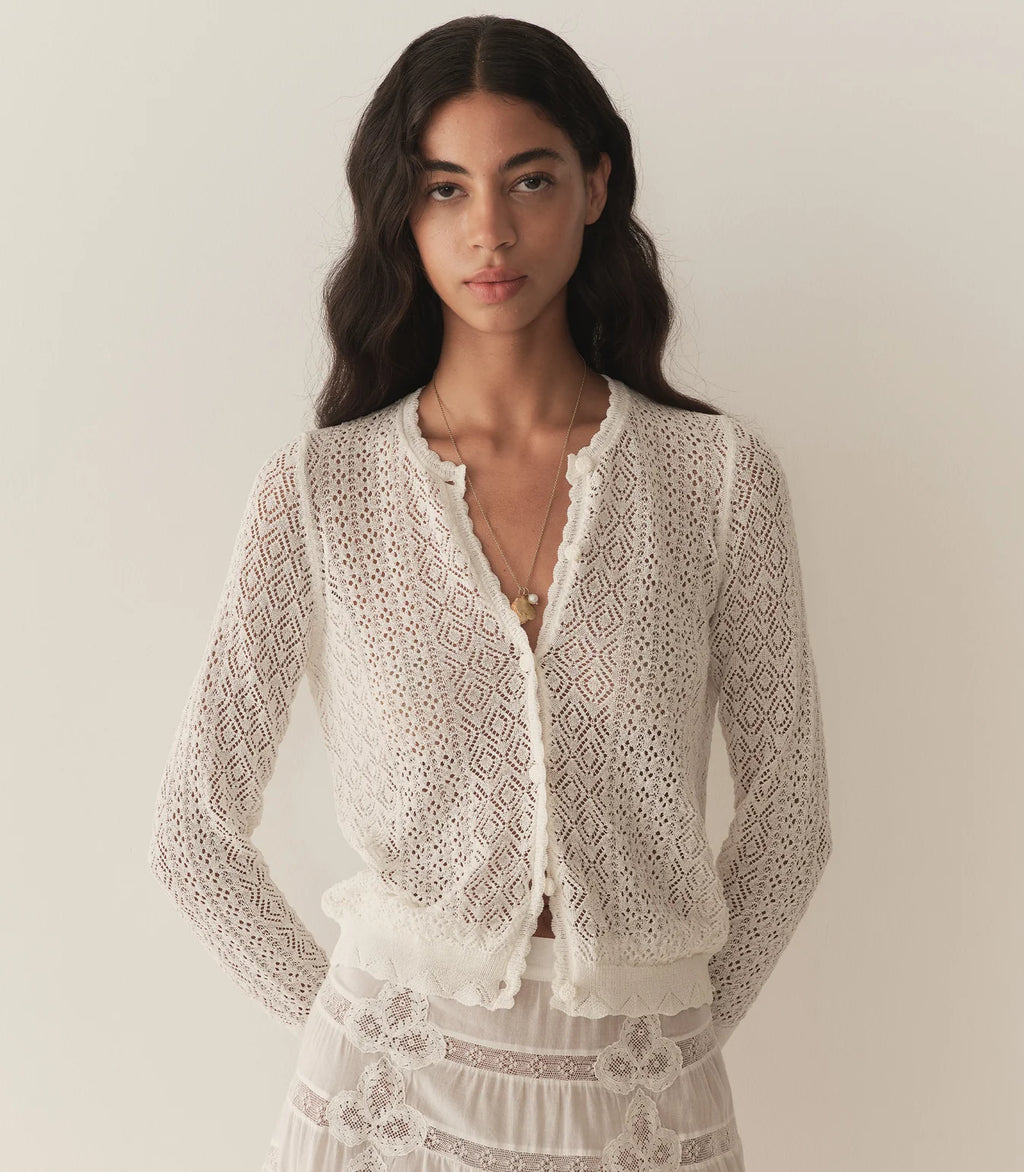 The Diane Cardigan by Doen brings timeless elegance to your everyday wardrobe. This sophisticated piece features a delicate pointelle design reminiscent of Victorian bobbin lace, crafted from a breathable viscose blend that drapes beautifully without feeling heavy. The classic crew neckline and bracelet-length sleeves offer versatile styling options, while charming crocheted buttons and scallop-edge ribbing at the neckline, cuffs, and hem add refined detail. 