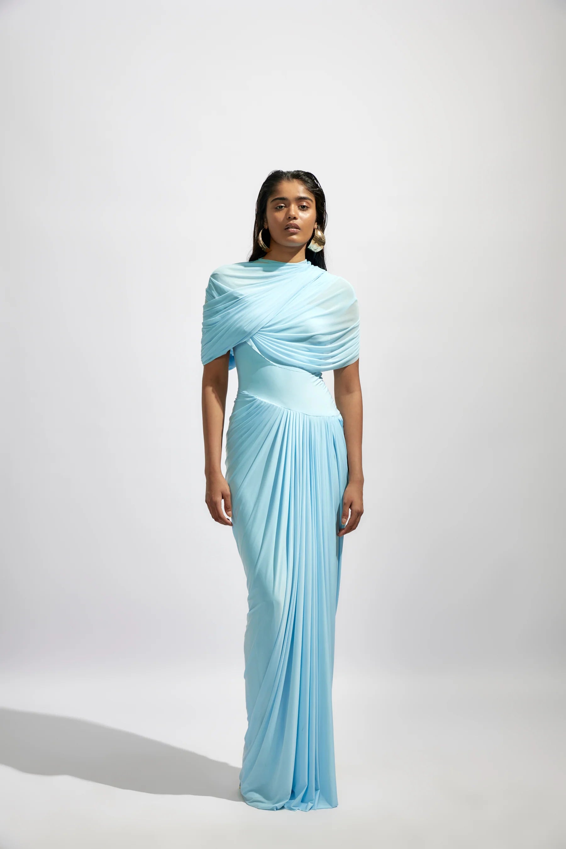 The Jasmine Dress features a fully draped design enhanced by delicate pleated details, adding texture and graceful movement. Its elegant silhouette and refined pleats bring timeless sophistication, making it an ideal choice for special occasions where you want to stand out with confidence and style.
