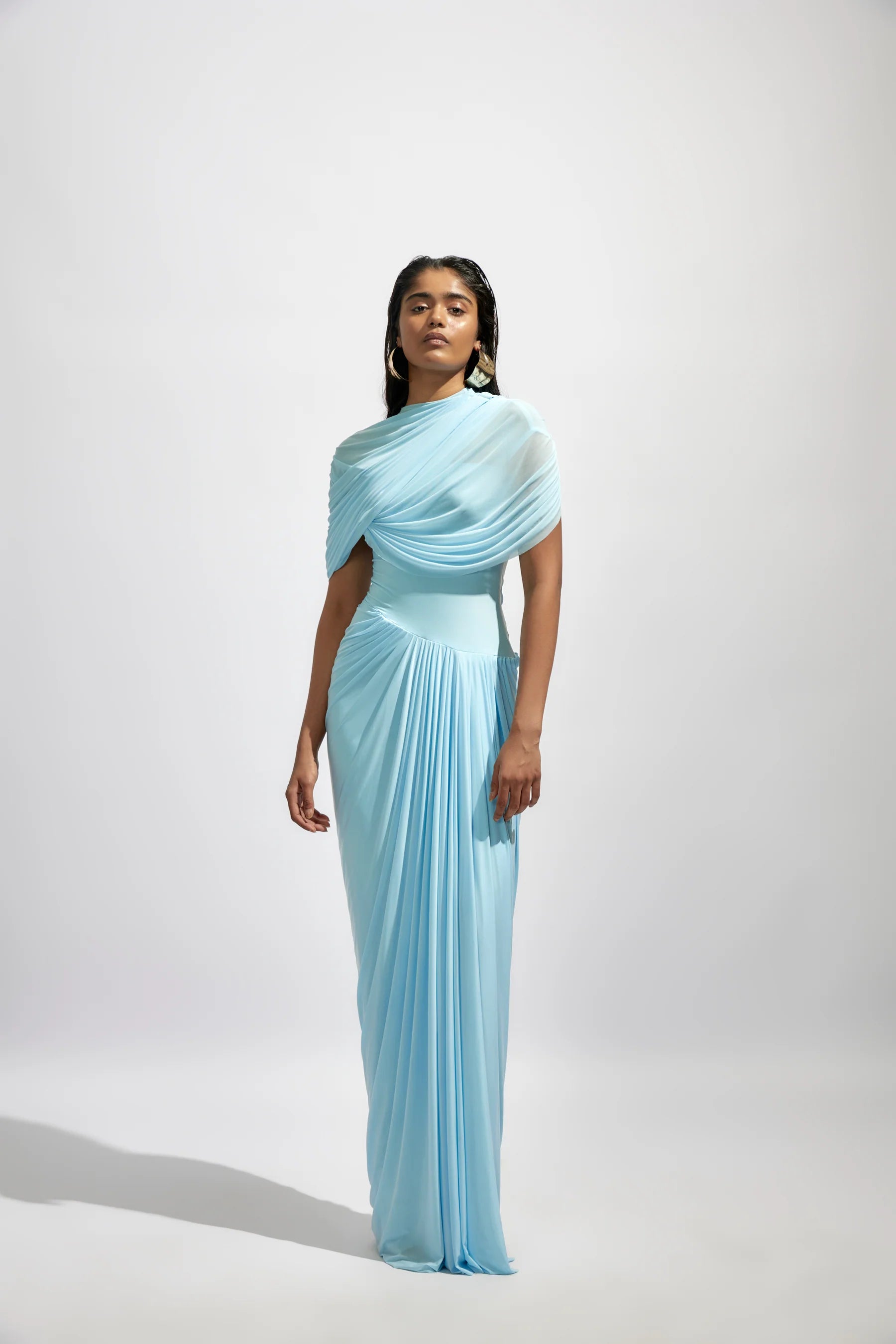 The Jasmine Dress features a fully draped design enhanced by delicate pleated details, adding texture and graceful movement. Its elegant silhouette and refined pleats bring timeless sophistication, making it an ideal choice for special occasions where you want to stand out with confidence and style.