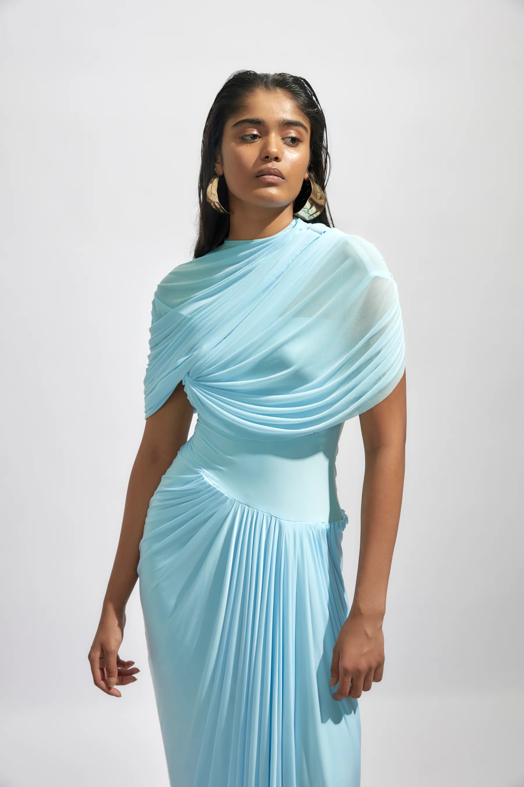 The Jasmine Dress features a fully draped design enhanced by delicate pleated details, adding texture and graceful movement. Its elegant silhouette and refined pleats bring timeless sophistication, making it an ideal choice for special occasions where you want to stand out with confidence and style.