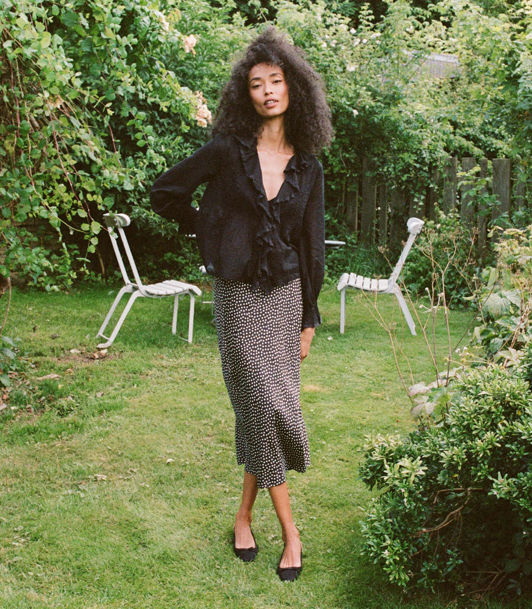 Introducing the Hardy Top in Black by Doen, an effortlessly elegant blouse that exudes French girl charm. With full sleeves, a delicate ruffle, and mother of pearl buttons, this blouse radiates sophistication. Crafted in 1970s-inspired pintucked design, it's perfect for any occasion - from casual outings to refined looks. Elevate your style with this versatile and comfortable blouse.