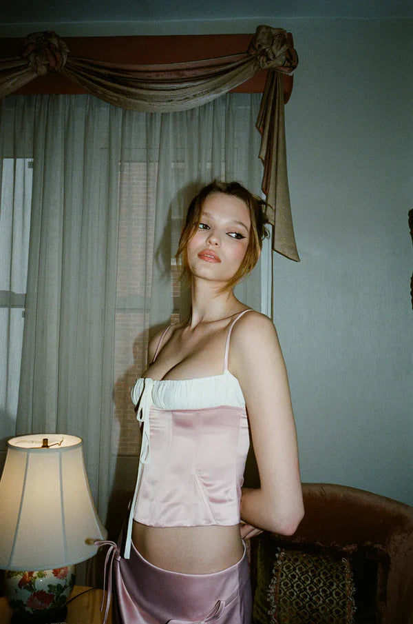 Elevate your style with the luxurious Sylvie Corset Top by With Jean. This top features elegant boning for a flattering silhouette and an adjustable straight neckline that highlights your curves. The adjustable ribbon and straps provide a perfect fit, while the side zip closure adds sophistication. Stand out in this exclusive piece!