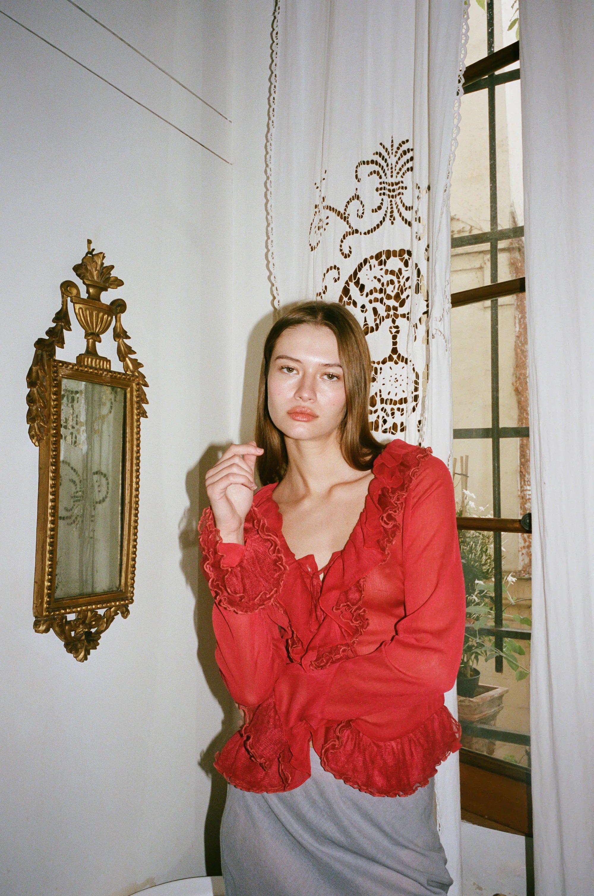 Indulge in the luxuriously elegant Maia Blouse by With Jean. With long sleeves, delicate ruffle detailing, and a semi-sheer design, this blouse exudes sophistication and charm. The button front closure adds a touch of understated class, making it the perfect addition to any upscale wardrobe. Unleash your inner fashionista with this exclusive piece.