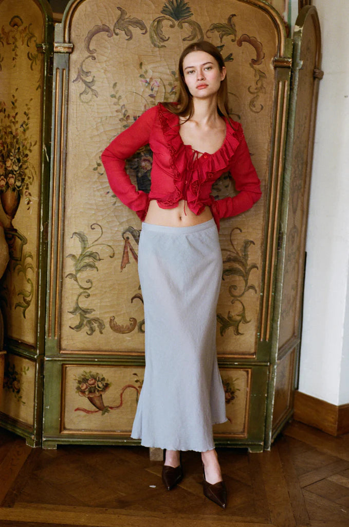 Indulge in the luxuriously elegant Maia Blouse by With Jean. With long sleeves, delicate ruffle detailing, and a semi-sheer design, this blouse exudes sophistication and charm. The button front closure adds a touch of understated class, making it the perfect addition to any upscale wardrobe. Unleash your inner fashionista with this exclusive piece.