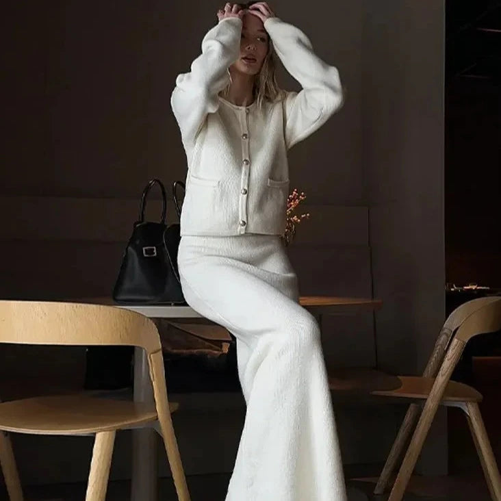Upgrade your wardrobe with Ensemble Dora: an elegant and stylish 2 piece set featuring a Golden O-neck cardigan and white knit midi skirt. Perfect for any occasion, this single-breasted ensemble will add a touch of elegance to your outfit while keeping you cozy and comfortable.