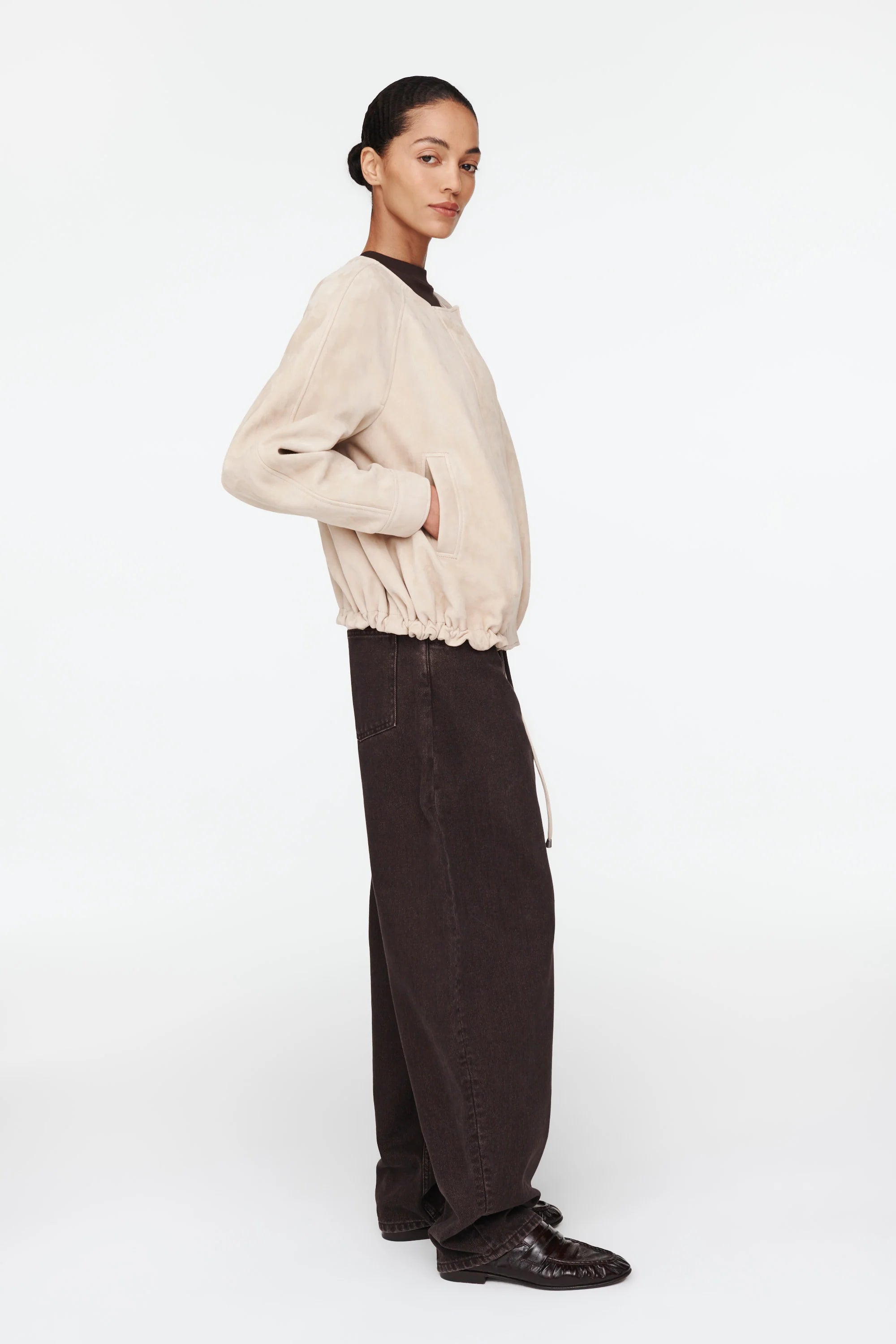 The Suki Suede Jacket redefines the classic aviator style with a sleek, collarless design for modern comfort. Its adjustable hem with drawstrings lets you customize your fit, making it perfect for daily wear. Crafted to be your go-to layer, this jacket combines style and functionality so seamlessly, you'll never want to take it off. Elevate your wardrobe with this versatile essential.