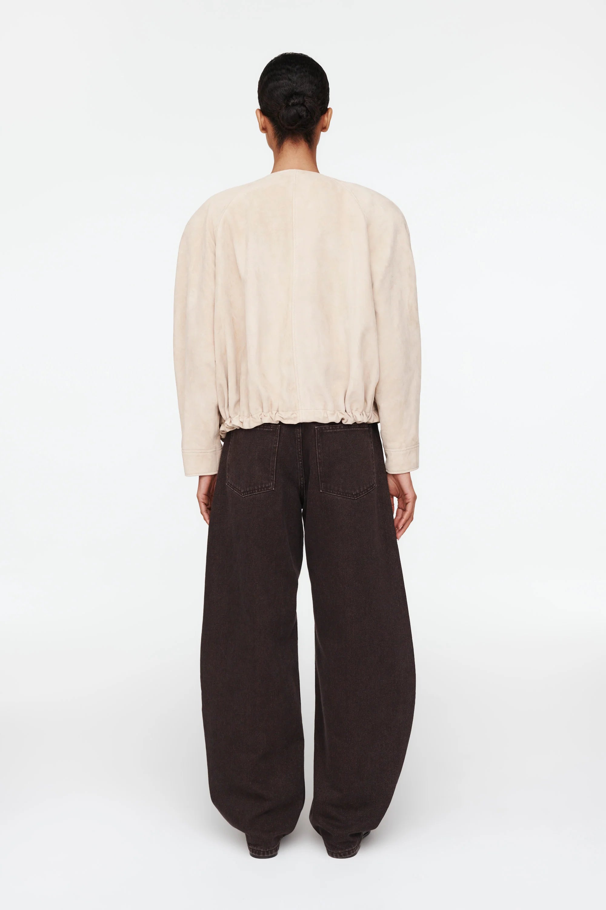 The Suki Suede Jacket redefines the classic aviator style with a sleek, collarless design for modern comfort. Its adjustable hem with drawstrings lets you customize your fit, making it perfect for daily wear. Crafted to be your go-to layer, this jacket combines style and functionality so seamlessly, you'll never want to take it off. Elevate your wardrobe with this versatile essential.