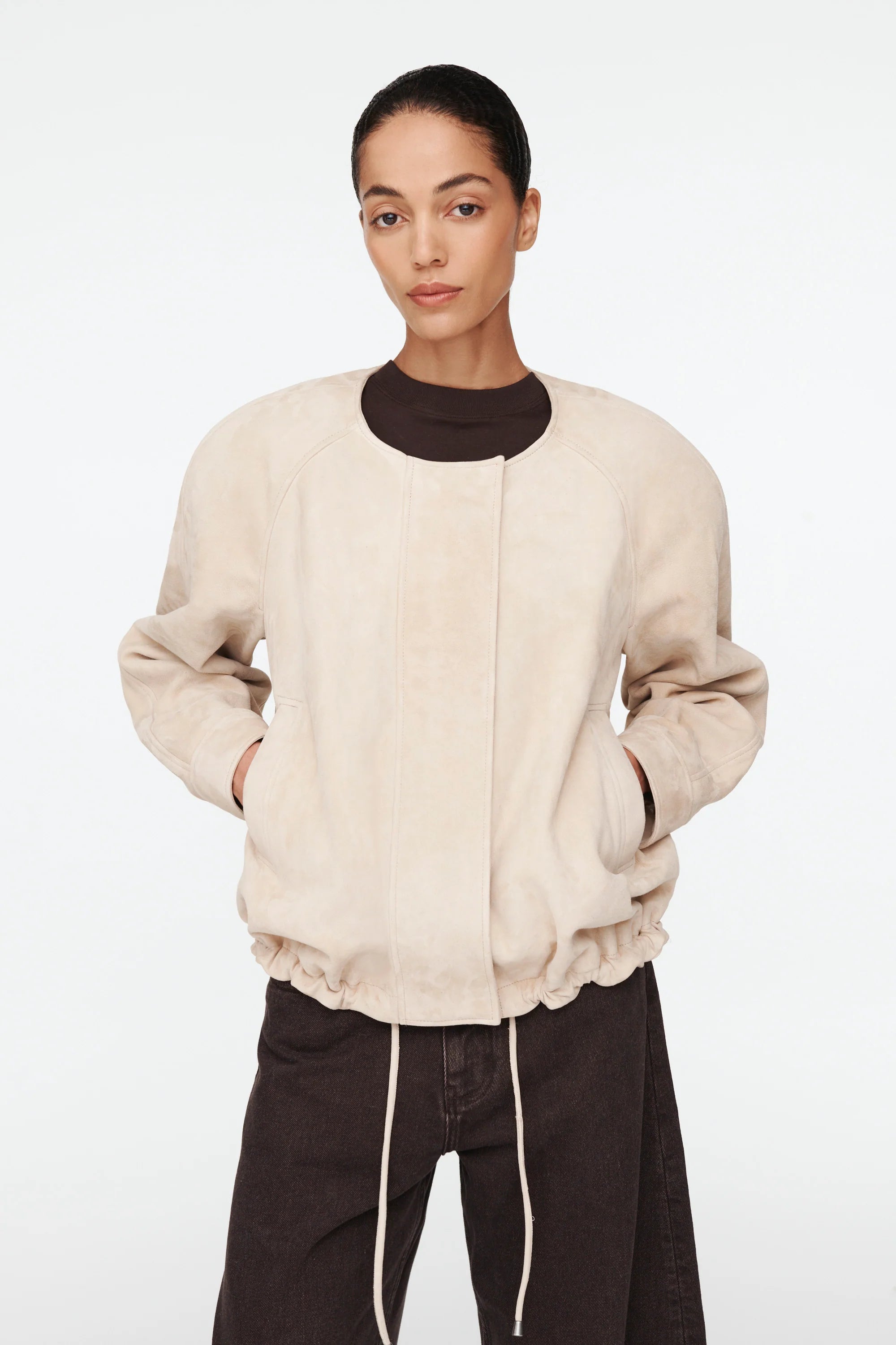 The Suki Suede Jacket redefines the classic aviator style with a sleek, collarless design for modern comfort. Its adjustable hem with drawstrings lets you customize your fit, making it perfect for daily wear. Crafted to be your go-to layer, this jacket combines style and functionality so seamlessly, you'll never want to take it off. Elevate your wardrobe with this versatile essential.