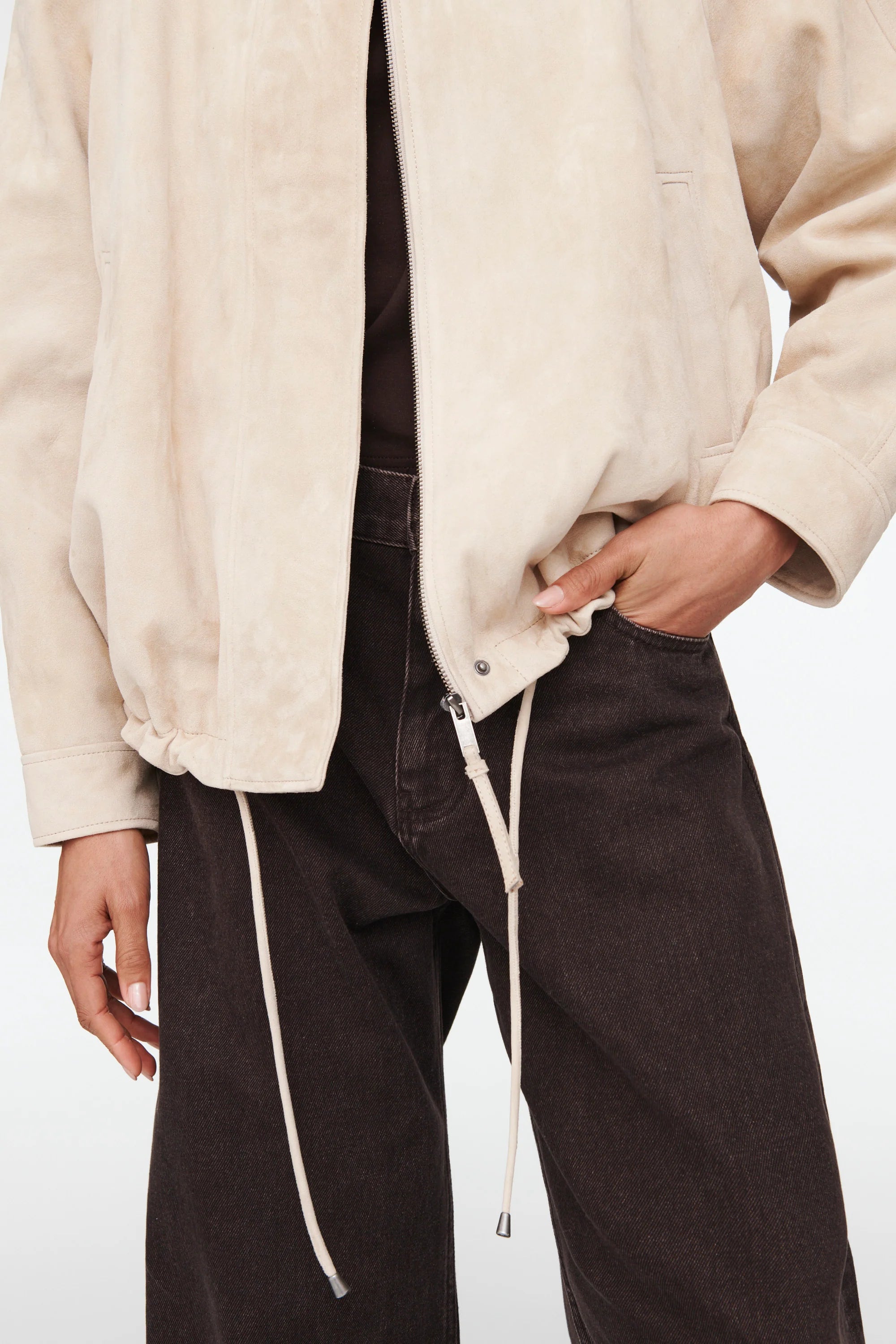 The Suki Suede Jacket redefines the classic aviator style with a sleek, collarless design for modern comfort. Its adjustable hem with drawstrings lets you customize your fit, making it perfect for daily wear. Crafted to be your go-to layer, this jacket combines style and functionality so seamlessly, you'll never want to take it off. Elevate your wardrobe with this versatile essential.