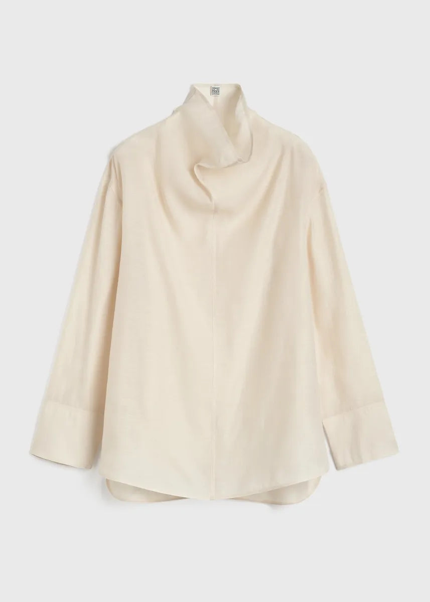 Elevate your wardrobe with this oversized funnel-neck organza blouse by Toteme, designed for effortless sophistication. The lightweight, semi-sheer fabric creates a delicate layering effect when paired with the included cami top. Its roomy fit and elegant neckline bring both comfort and style, making it ideal for pairing with tailored trousers for a polished daytime look. Perfect for those seeking a chic, versatile piece that enhances any outfit with a graceful touch.