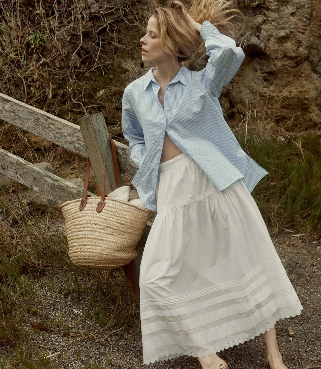 Elevate your wardrobe with the Hava Top in Santorini Stripe by Doen. Made from luxurious Italian cotton, this button-down features a sophisticated Santorini Stripe pattern and mother-of-pearl buttons. The embroidered and shirring details add unique flair to its tailored silhouette, perfect for both casual and polished looks. Versatile and elegant, it's a must-have for any fashion-forward individual.