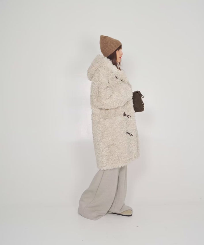 Wrap yourself in Nordic sophistication with the Teddy Coat. This luxurious faux fur piece combines sumptuous softness with practical design—featuring a cozy hood and charming toggle closures that blend timeless elegance with contemporary ease. The voluminous silhouette delivers exceptional warmth without sacrificing style, making it the perfect statement piece for elevating your winter wardrobe. Experience the perfect balance of comfort and chic refinement.