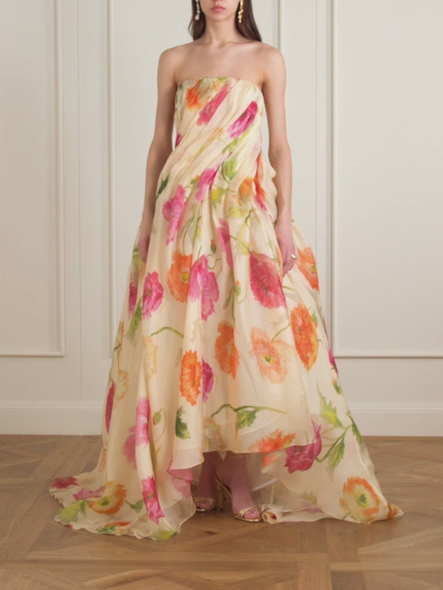 Synonymous with red-carpet glamour, this strapless gown embodies timeless sophistication. Crafted from luxurious silk crêpe organza, it features an elegant high-low hemline and an allover vibrant poppy print that commands attention. The structured bustier silhouette delivers refined support and drama—a showstopping choice for unforgettable evenings.