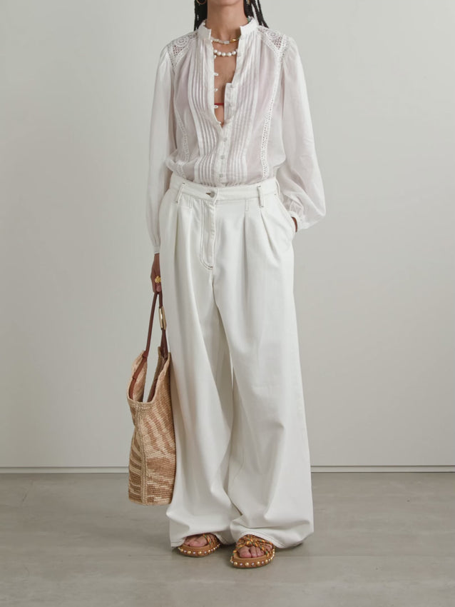 Elevate your wardrobe with the Greicy shirt, a refined piece that seamlessly blends delicate craftsmanship with effortless elegance. Crafted from crisp cotton-voile, this semi-sheer design features intricate guipure lace trim and subtle pintucking for understated sophistication. The loose, slightly cropped silhouette offers a contemporary take on classic tailoring, while the buttoned front and single-button cuffs provide polished finishing touches. 