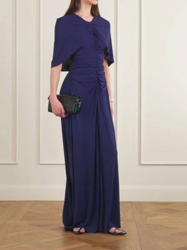 Matilda captures contemporary sophistication in sumptuous jersey crafted from certified sustainable fibers. The signature ruched cape-effect panel and fitted bodice create an elegant silhouette that moves with fluid grace, while the floor-length hem and thigh-high split deliver timeless allure. Pair with statement heels to complete the look.