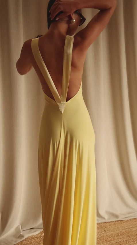 Introducing the Rosa Gown in Lemon—an elegant statement piece designed for those who appreciate refined sophistication. This stunning gown features a daring plunged neckline and gracefully low back, both beautifully accentuated with luxurious 100% silk trim detailing that catches the light with every movement. Crafted from sumptuous soft jersey fabric, the Rosa drapes beautifully against the body, creating a flattering silhouette that moves with you.