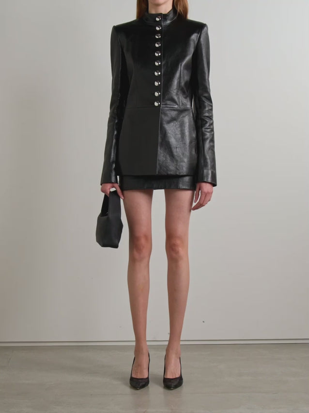The Samuel jacket merges military precision with haute couture elegance. Crafted from luxuriously supple black leather, this statement piece features a distinctive grandad collar and gleaming silver-tone buttons that elevate its utilitarian roots. Structured padded shoulders create commanding silhouette while a refined nipped waist maintains flattering proportions. Finished with sumptuous satin lining for effortless layering, it's the ultimate investment in timeless, versatile style.